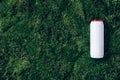 White plastic bottle of detergent powder or cleaning agent on green grass, moss background. Copy space. Top view. Flat Royalty Free Stock Photo