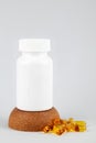 White plastic bottle with pills on a brown cork isolated on white background Royalty Free Stock Photo