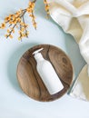 White plastic bottle with pump, used for liquid soap, shampoo and lotion on wood tray on blue background Royalty Free Stock Photo