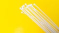 White plastic cable ties isolated on yellow background Royalty Free Stock Photo