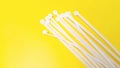 White plastic cable ties isolated on yellow background Royalty Free Stock Photo