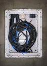 White plastic cables box with black wires installed on new gray wall at construction site Royalty Free Stock Photo