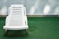 White plastic chair, chaise lounge on the grass. Background with copy space. Concept of free time, vacation, sunbathing Royalty Free Stock Photo