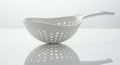 White Plastic Colander with Handle and Reflection on White Surface Royalty Free Stock Photo
