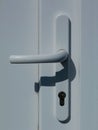 White plastic door handle and lock and shadow Royalty Free Stock Photo