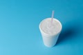 White plastic cup isolated on blue background.