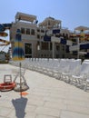 white plastic deck chairs standing in front of each other near the swimming pool with blue tile