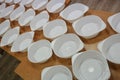 White plastic deep disposable plates stand on a wooden table. zero weist, recycling, global warming