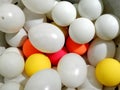 White plastic eggs and balls of different color laying together
