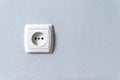 White plastic euro socket on gray wall with copyspace Royalty Free Stock Photo