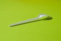 White plastic fork on a green background Royalty Free Stock Photo