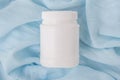 White plastic jar with vitamins and bioactive additives. Useful pills for youthful skin on a beautiful blue background with copy