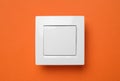 White plastic light switch on orange background Royalty Free Stock Photo