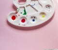 plastic palette with paints on a pink background, artist tool Royalty Free Stock Photo