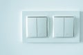 White plastic pass-through electricity switches on a white wall