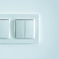 White plastic pass-through electricity switches on a white wall