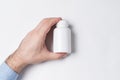 White plastic Pill Bottle in male hand. medicine package plastic mock up Royalty Free Stock Photo