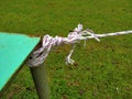 White plastic rope tied and knotted at the end of the green iron table pole. Royalty Free Stock Photo