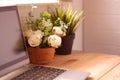 White plastic roses flowers on a desk with a computer laptop on a wooden floor Royalty Free Stock Photo