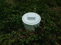 White plastic sewer clean out pipe in green grass Royalty Free Stock Photo