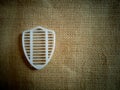 White plastic shield isolated on gunny sack. Daylight Royalty Free Stock Photo