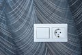 White plastic switched double socket. Light switch and power socket control panel on abstract wallpaper, close-up. Electrical Royalty Free Stock Photo