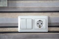 White plastic switched double socket. Light switch and power socket control panel on wall, close-up. Electrical european equipment Royalty Free Stock Photo