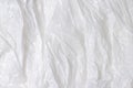 White plastic wrap background. Crumpled wrinkled plastic cellophane. Reflecting light and shadow on creases and folds in Royalty Free Stock Photo