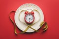 White plate with alarm clock and yellow measuring heart shaped tape.Dinner concept Royalty Free Stock Photo