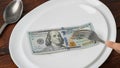$ 100 is on a white plate. America, USA, dollar. Concept. Eat money, living wage. Economy, Central Asia. Sawing the budget,