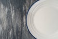 White plate with blue border on a beautiful gray wooden background Royalty Free Stock Photo