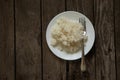 White plate with boiled rice on an old wooden board as a background Royalty Free Stock Photo
