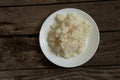 White plate with boiled rice on an old wooden board as a background Royalty Free Stock Photo