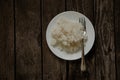 White plate with boiled rice on an old wooden board as a background Royalty Free Stock Photo