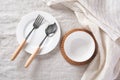 White plate and bowl with spoon, fork and linen napkin on tablecloth Royalty Free Stock Photo