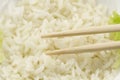 White plate of cooked long-grain rice on wooden background. Healthy eating, diet Royalty Free Stock Photo