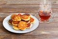 White plate with cottage cheese pancakes and cup of tea Royalty Free Stock Photo