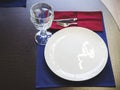 White plate with a crystal glass fork and knife on a blue napkin on a wooden table. Closeup photo Royalty Free Stock Photo