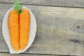 White plate with cut carrots on wooden table rustic