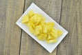 White plate with cut pieapple on table Royalty Free Stock Photo