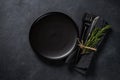 White plate, cutlery and napkin on black table top view. Royalty Free Stock Photo