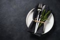 White plate, cutlery and napkin on black table top view. Royalty Free Stock Photo