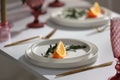 White plate decorated on white table and pink glass. Wedding decoration