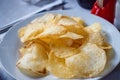 White plate with delicious golden potato chips