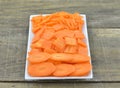 White plate with different slices carrots on wooden table, closeup Royalty Free Stock Photo