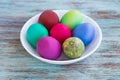 White plate with Easter versicolored eggs on wooden background