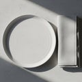 White plate and folded napkin on a textured gray surface. The plate is round with sub Royalty Free Stock Photo
