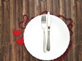 White plate, fork, knife, heart wooden background Royalty Free Stock Photo