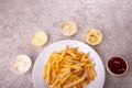White plate of french fries chips potato and sauces on gry concrete background. top view. copy spacce Royalty Free Stock Photo