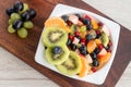 In a white plate, fresh homemade vitamin fruit salad for breakfast. Royalty Free Stock Photo